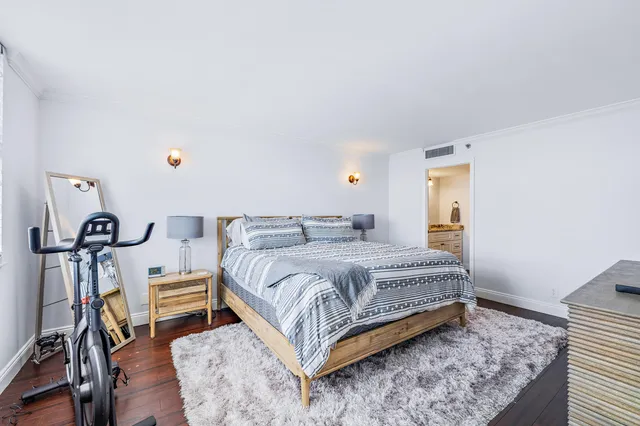 a bedroom with a bed and wooden floor