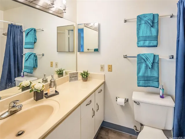 a bathroom with a granite countertop sink mirror vanity and toilet