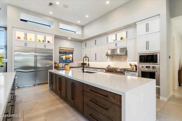 a kitchen with stainless steel appliances a stove refrigerator sink and cabinets