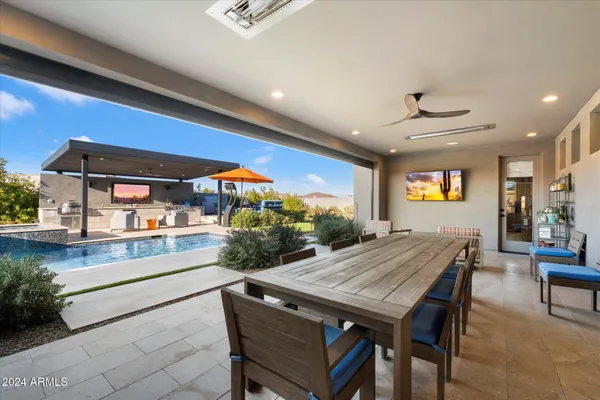 a view of a patio with couches and dining table with garden view