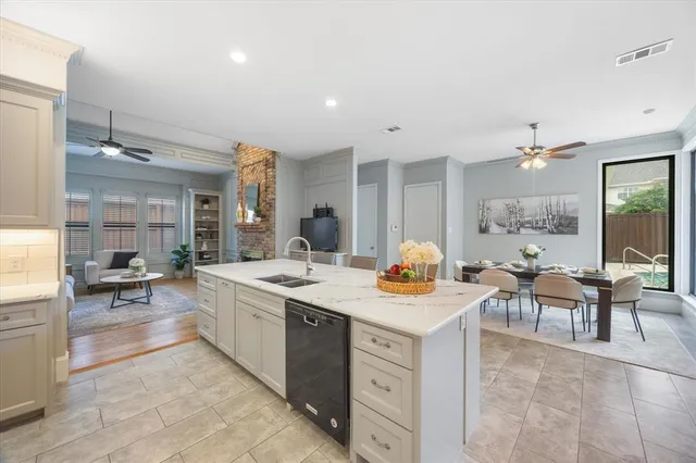 a view of a kitchen with kitchen island a sink a stove a dining table and chairs