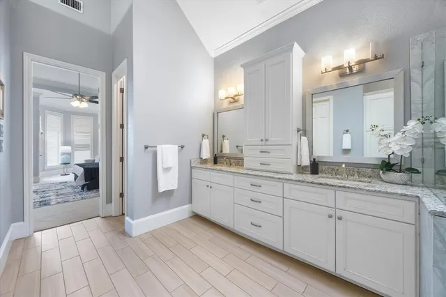 a spacious bathroom with a granite countertop sink mirror and a shower
