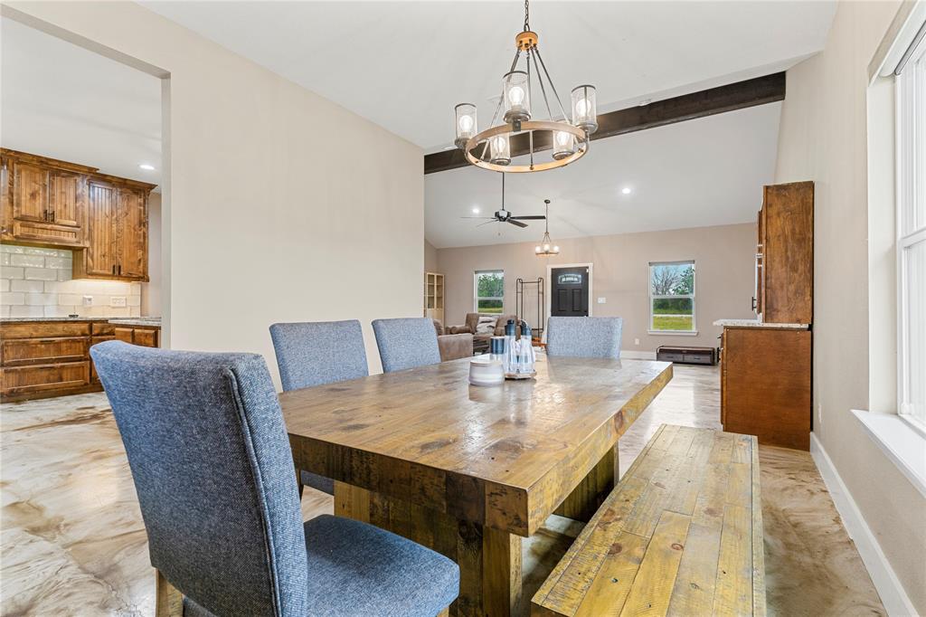 139 Kriston Lane Springtown, TX 76082 - Photo 11 of 39 Dining area featuring a substantial wood-finish table and a wagon wheel chandelier