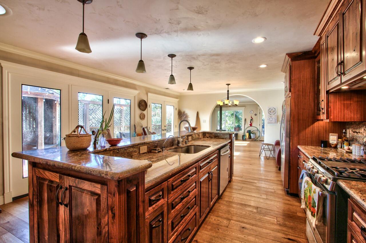545 Pini Road Watsonville, CA 95076 - Photo 3 of 18 a kitchen with stainless steel appliances a stove a sink dishwasher and a dining table with wooden floor