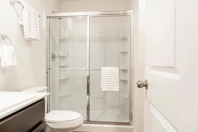 a bathroom with a sink a toilet and shower