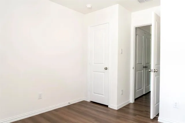 a view of a small space with wooden floor and a window