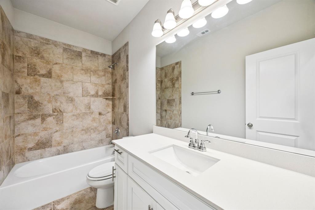 8081 Snowmass Drive Frisco, TX 75034 - Photo 17 of 25 a bathroom with a granite countertop sink a toilet a mirror a bathtub and shower