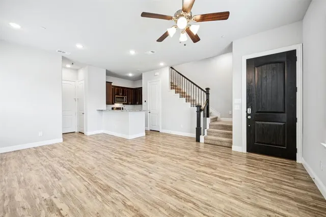 a view of empty room with wooden floor and ceiling fan