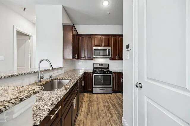 a kitchen with stainless steel appliances granite countertop a sink stove and refrigerator