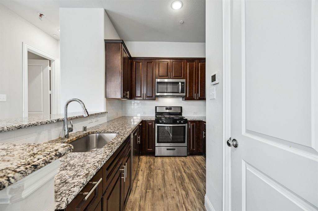 8081 Snowmass Drive Frisco, TX 75034 - Photo 6 of 25 a kitchen with stainless steel appliances granite countertop a sink stove and refrigerator