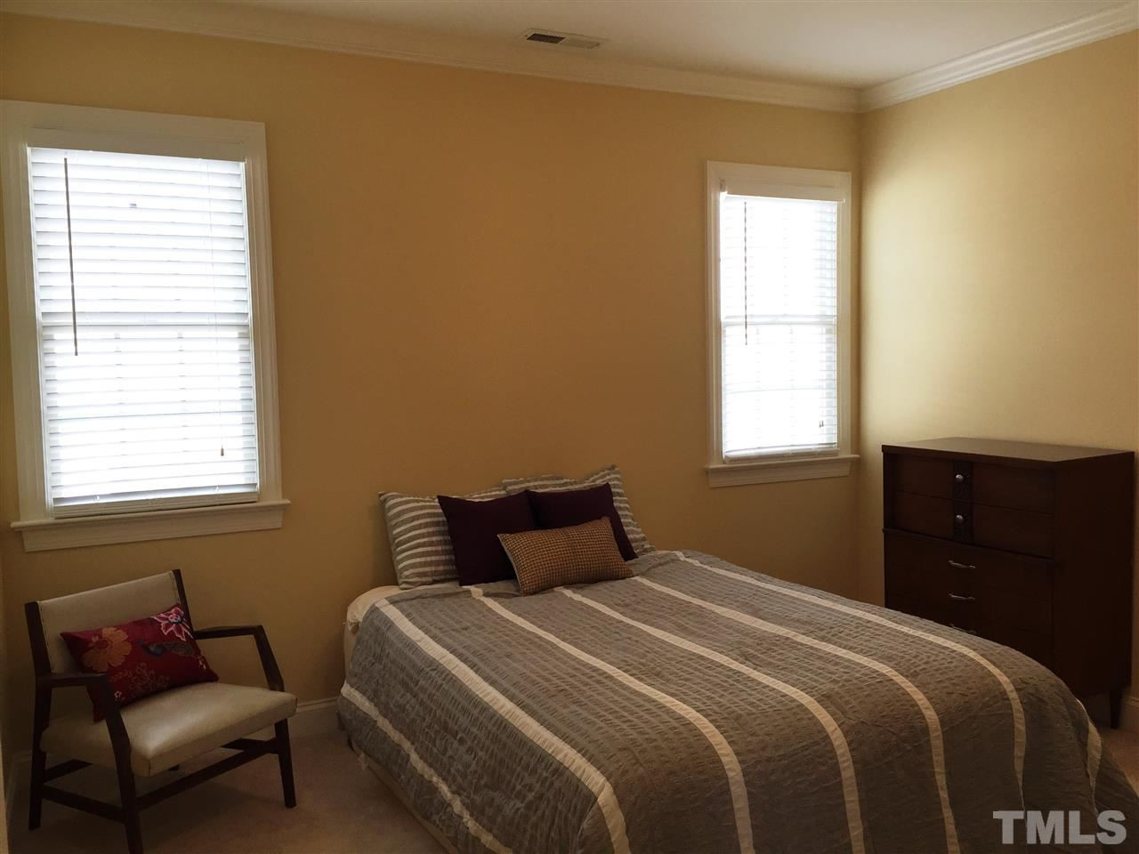 1307 Ileagnes Road Raleigh, NC 27603 - Photo 20 of 24 Bedroom 3 also features crown molding, two windows, and a large walk-in closet with multi hanging levels and shelving. Bedroom 3
