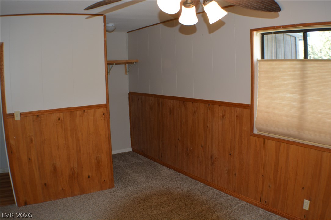 1321 Trout Canyon Road Las Vegas, NV 89124 - Photo 26 of 50 A cozy bedroom with rich wood paneling and a ceiling fan, ready for personal touches.