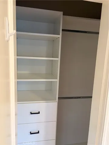 a view of walk in closet with empty racks