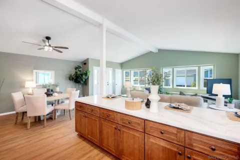 a large living room with stainless steel appliances kitchen island granite countertop furniture and a large window