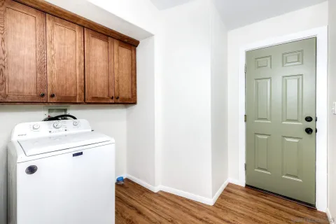 a utility room with wooden floor washer and dryer