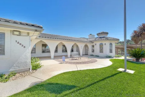a view of a house with backyard and sitting area
