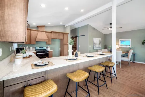 a kitchen with kitchen island a stove a table and chairs in it