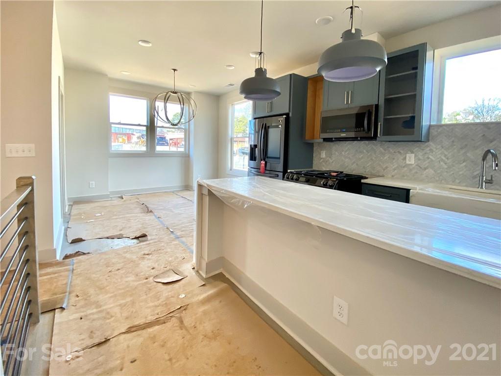 2335 Wesley Village Road, Unit 35 Charlotte, NC 28208 - Photo 26 of 28 a kitchen with kitchen island granite countertop a sink and a stove top oven