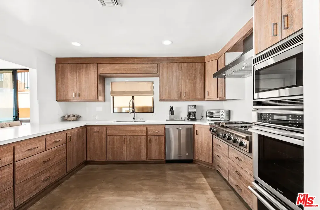 24608 Malibu Road Malibu, CA 90265 - Photo 12 of 30 a kitchen with stainless steel appliances granite countertop a stove sink and cabinets