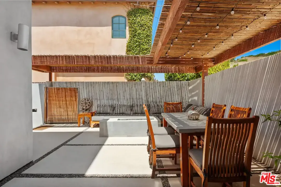 24608 Malibu Road Malibu, CA 90265 - Photo 20 of 30 a view of a patio with table and chairs with wooden fence
