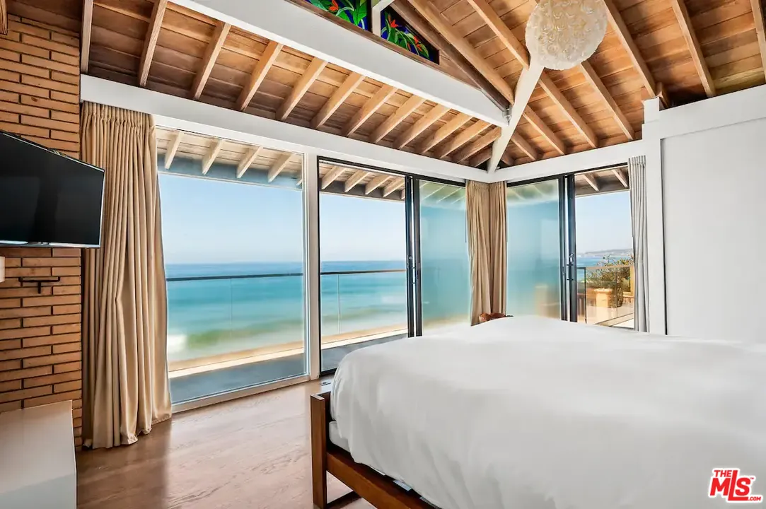 24608 Malibu Road Malibu, CA 90265 - Photo 26 of 30 a large bed sitting in a bedroom next to a window