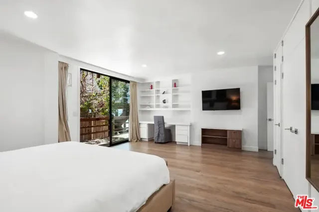 a large room with a bed and wooden floor