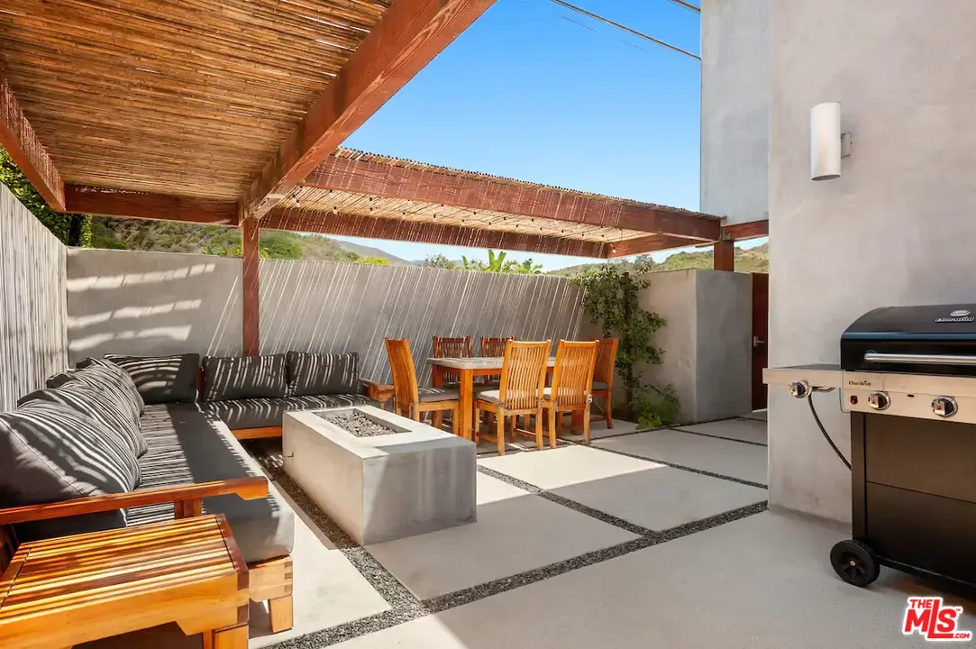 24608 Malibu Road Malibu, CA 90265 - Photo 10 of 30 a view of a patio with a table and chairs under an umbrella