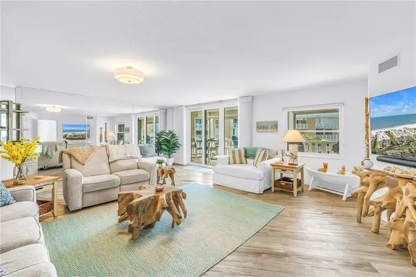 a living room with furniture a dining table and a wooden floor
