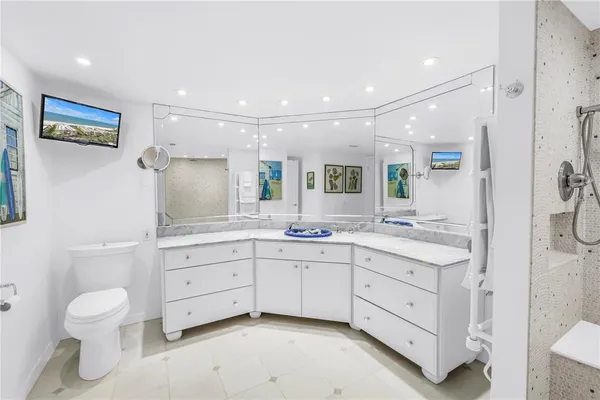 a bathroom with a granite countertop sink a mirror and a bathtub