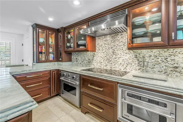 a kitchen with stainless steel appliances granite countertop a sink stove and cabinets