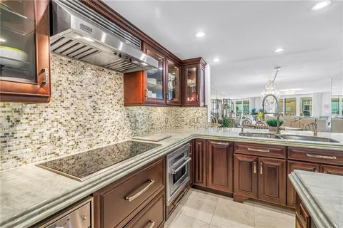 a kitchen with stainless steel appliances granite countertop a sink and a refrigerator