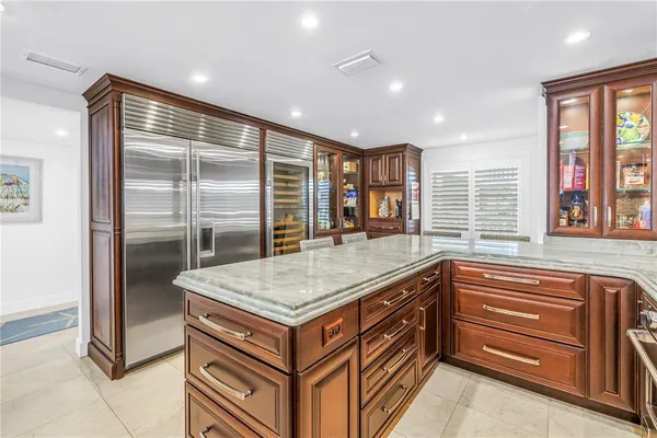 a view of a dining room with furniture a kitchen and chandelier