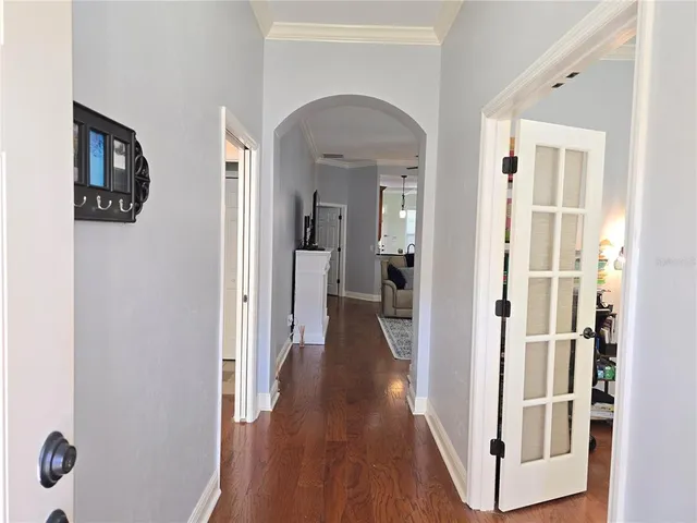 a view of a hallway with wooden floor and closet