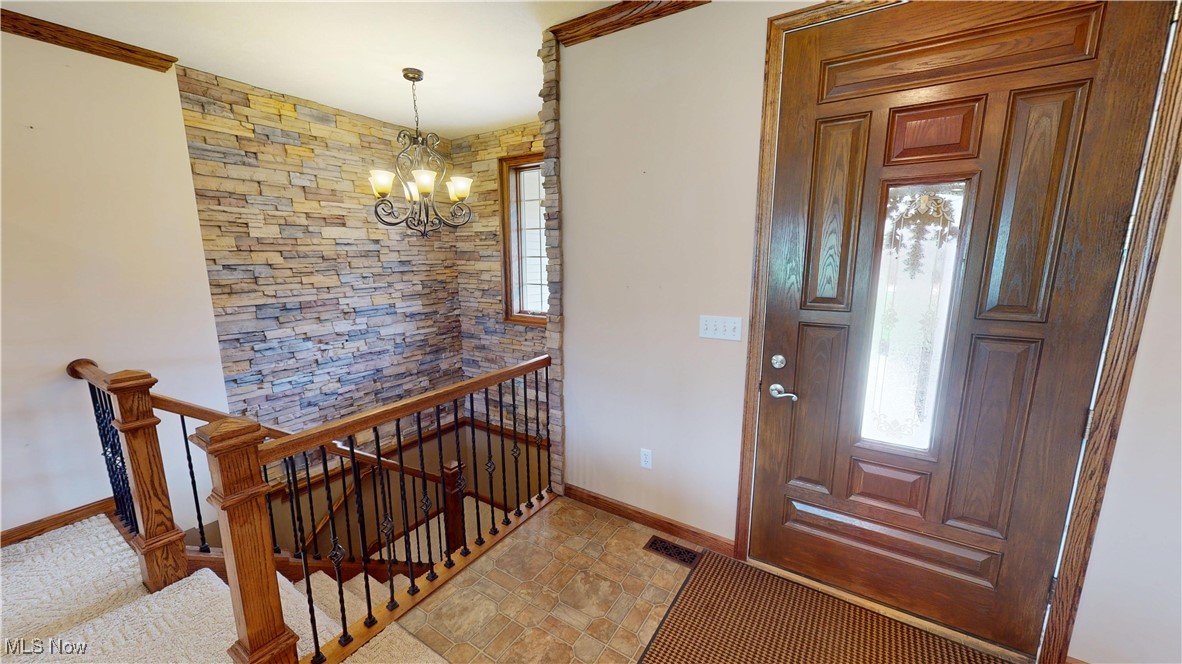 10323 Smith Road Litchfield, OH 44253 - Photo 4 of 50 Foyer entrance with baseboards, visible vents, and an inviting chandelier