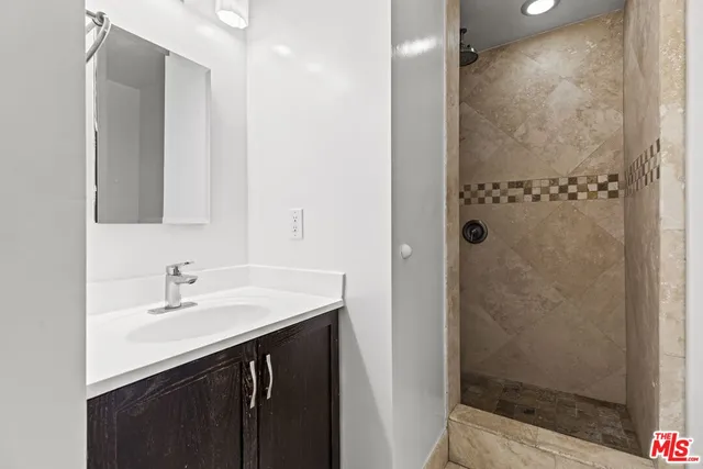 a bathroom with a sink a mirror and shower