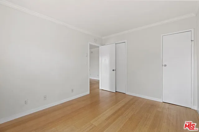 a view of an empty room with wooden floor