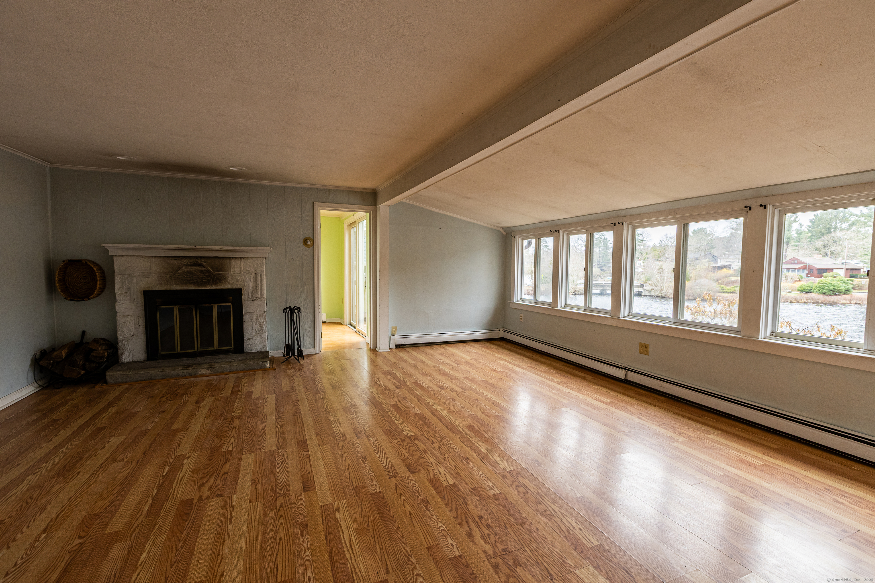 24 Echo Point Road Guilford, CT 06437 - Photo 13 of 30 an empty room with wooden floor fireplace and windows