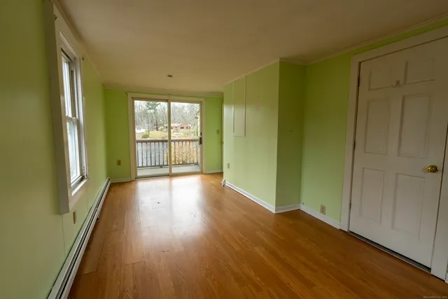 a view of a hallway with wooden floor and windows