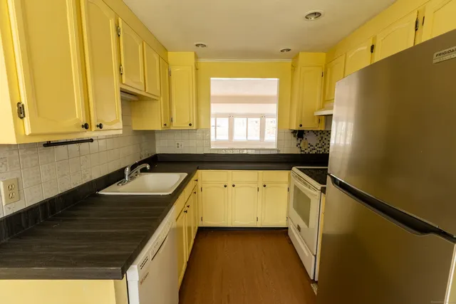 a kitchen with a sink a refrigerator and window