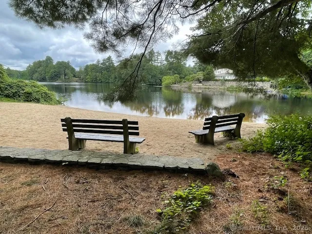a view of a lake in between two chairs next to a yard