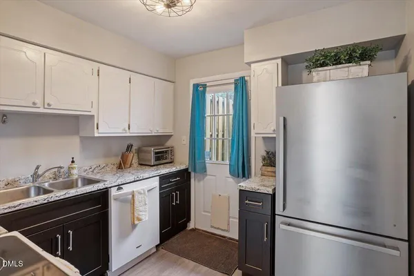 a kitchen with cabinets appliances a sink and a counter top