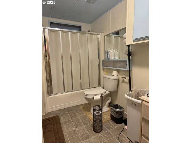 a bathroom with a toilet and a shower