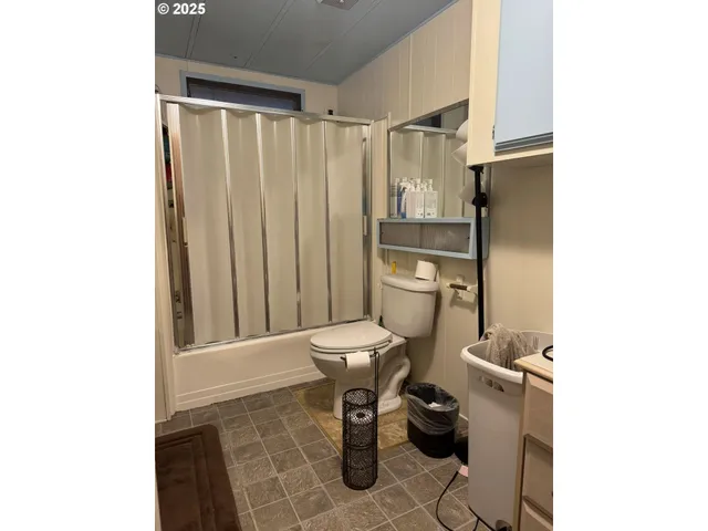 a bathroom with a toilet and a shower