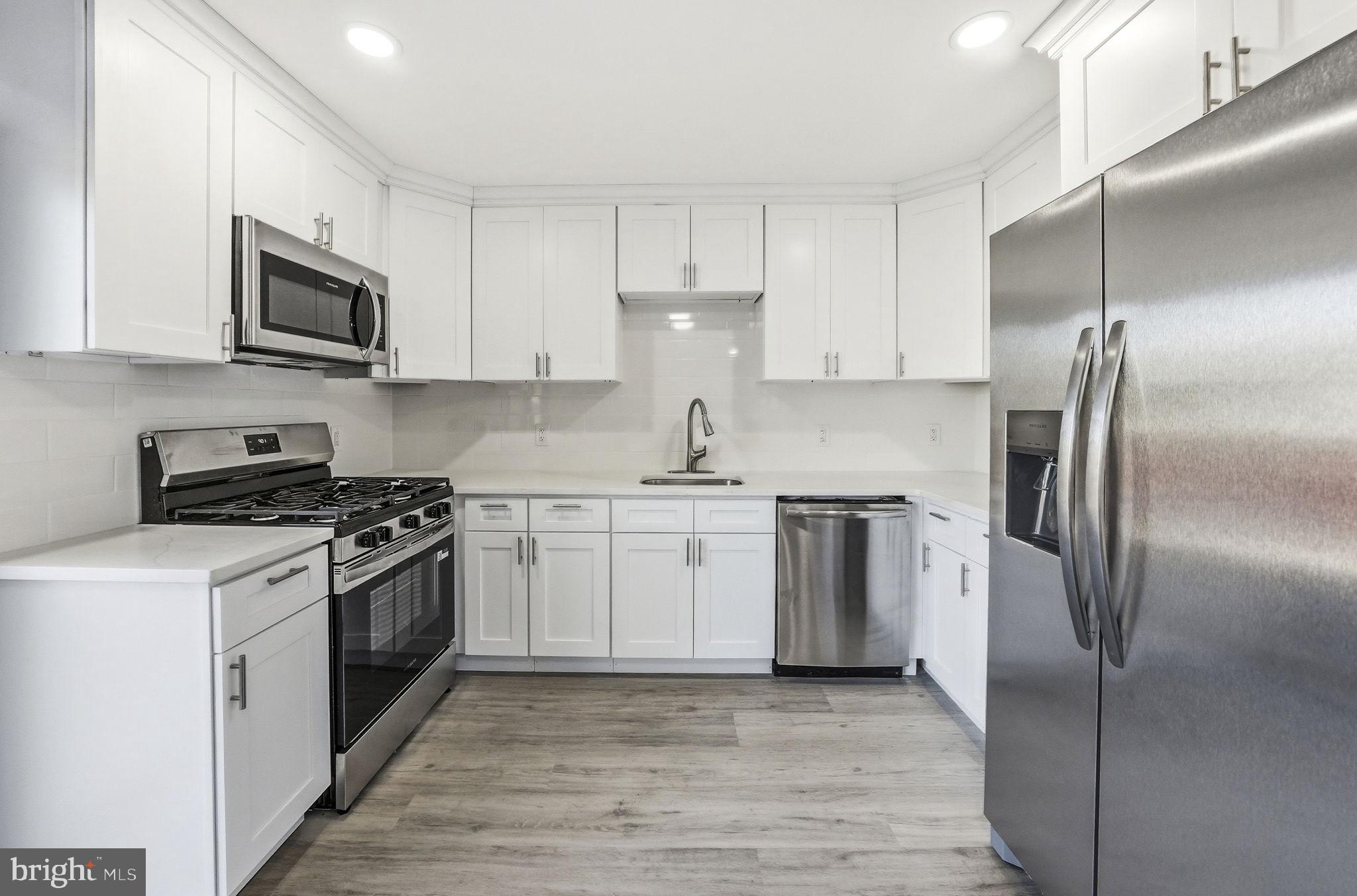 371 Bolton Road East Windsor, NJ 08520 - Photo 3 of 20 a kitchen with stainless steel appliances granite countertop a refrigerator a stove top oven a sink and dishwasher with wooden floor