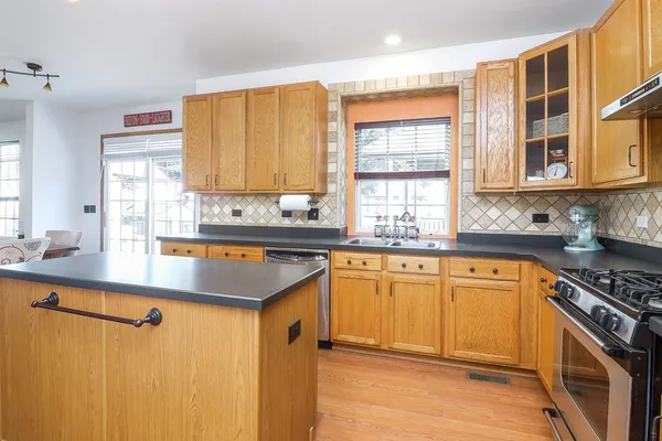 a kitchen with stainless steel appliances granite countertop a sink stove and cabinets