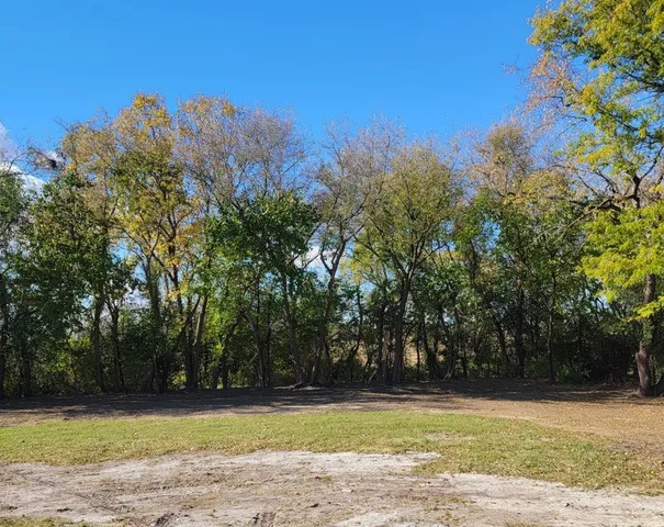 a view of a large pool with lawn chairs under an umbrella