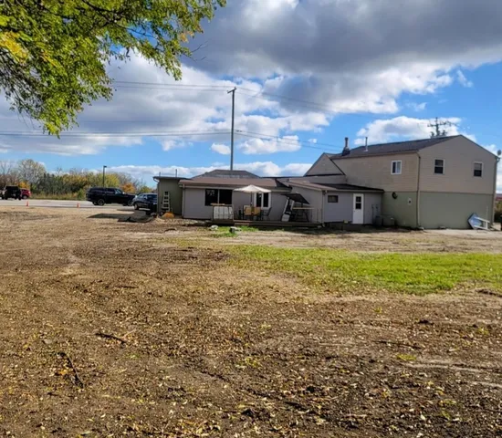 a view of a house with a big yard and large tree