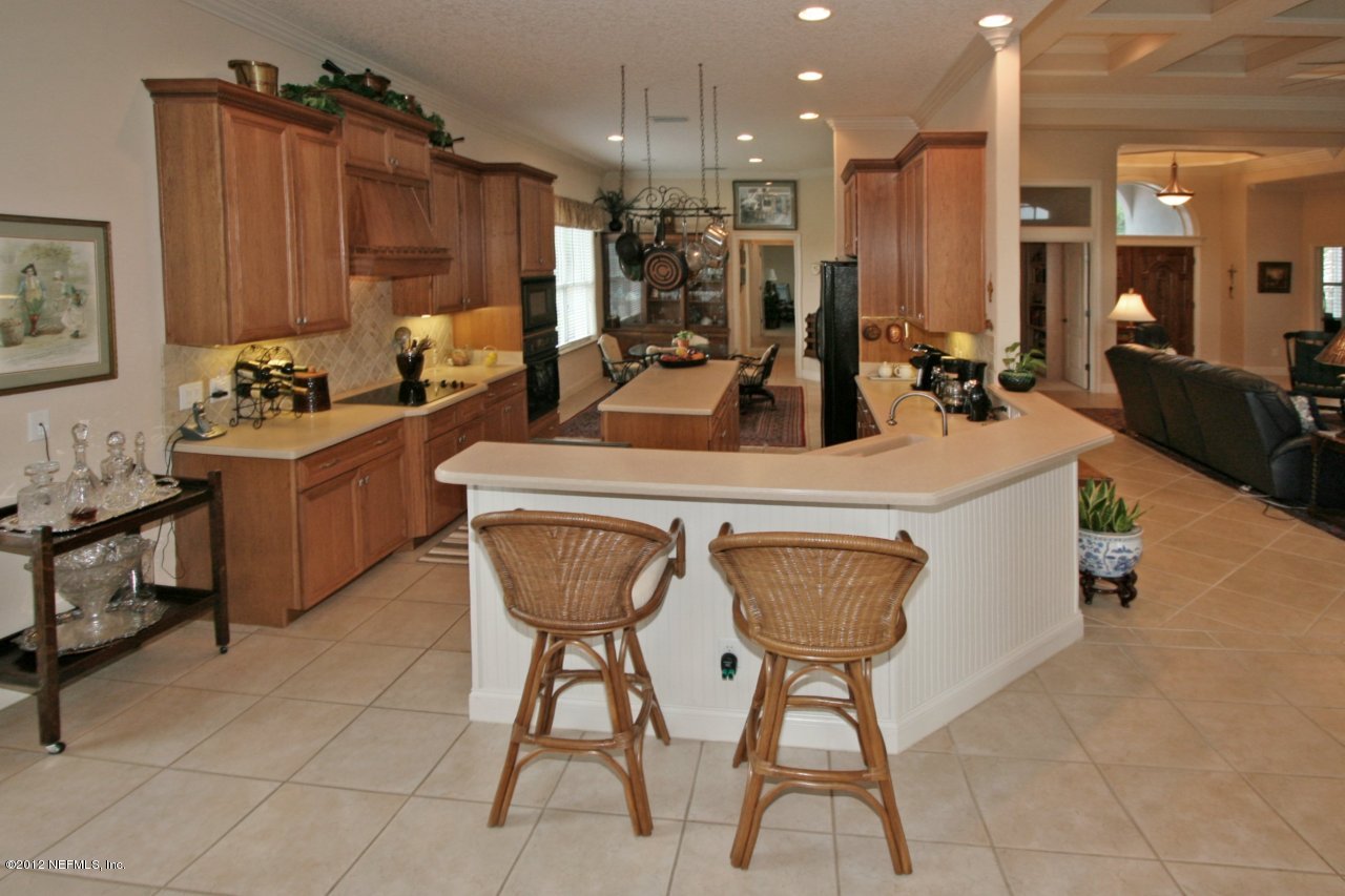 349 Fiddlers Point Drive St. Augustine, FL 32080 - Photo 15 of 27 a kitchen with stainless steel appliances kitchen island granite countertop a sink and a refrigerator