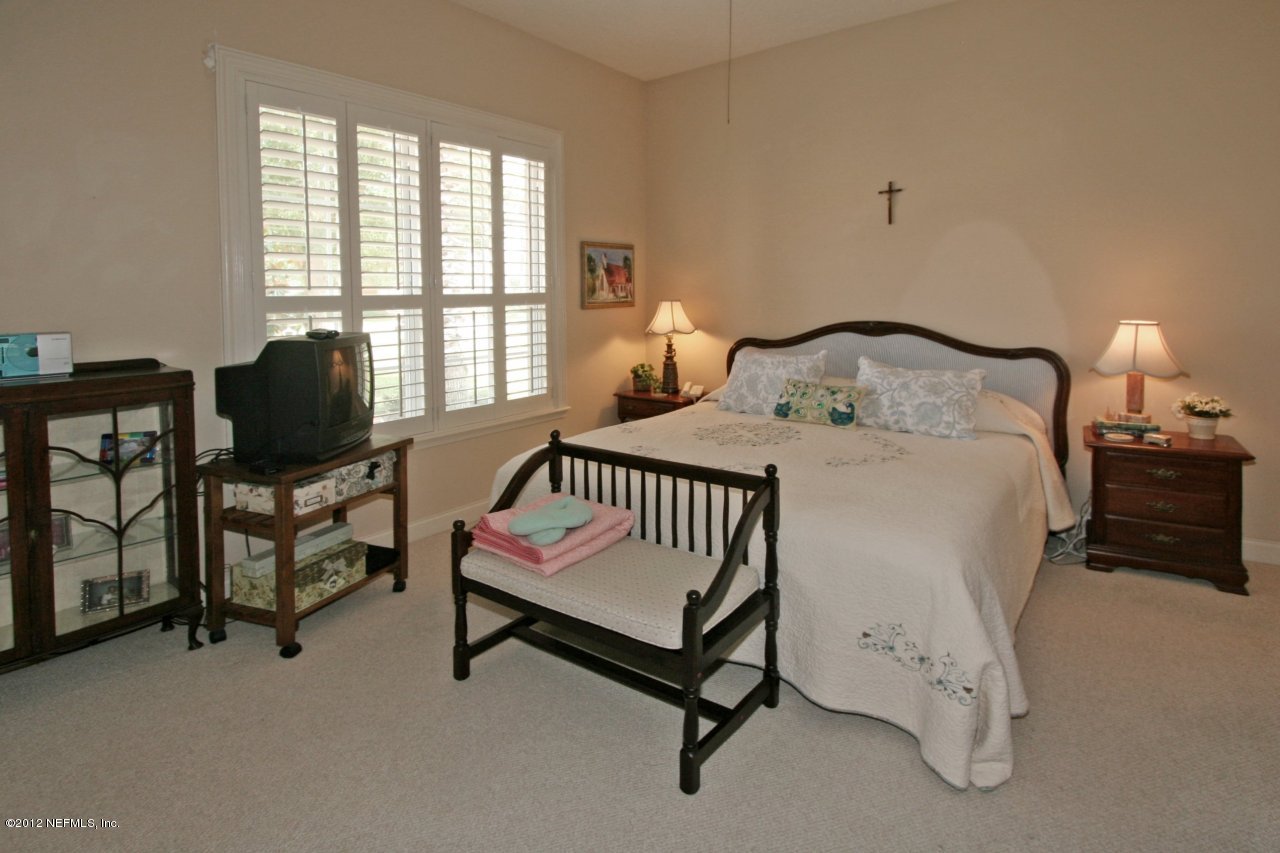 349 Fiddlers Point Drive St. Augustine, FL 32080 - Photo 19 of 27 a bedroom with a bed and a chair