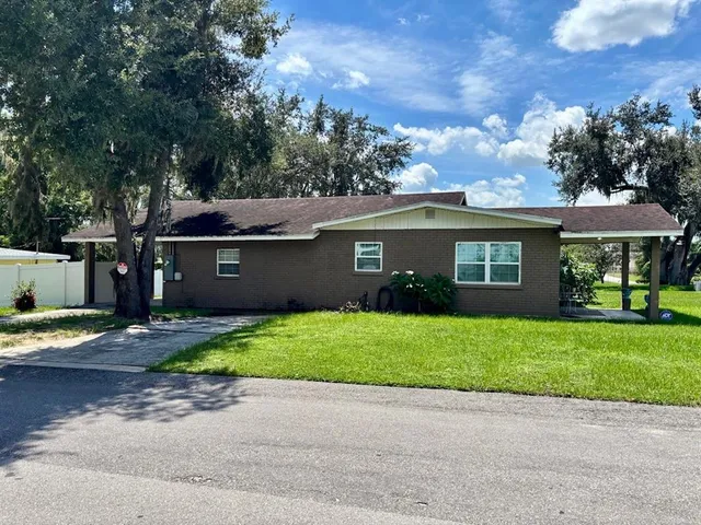 a front view of a house with a garden and trees